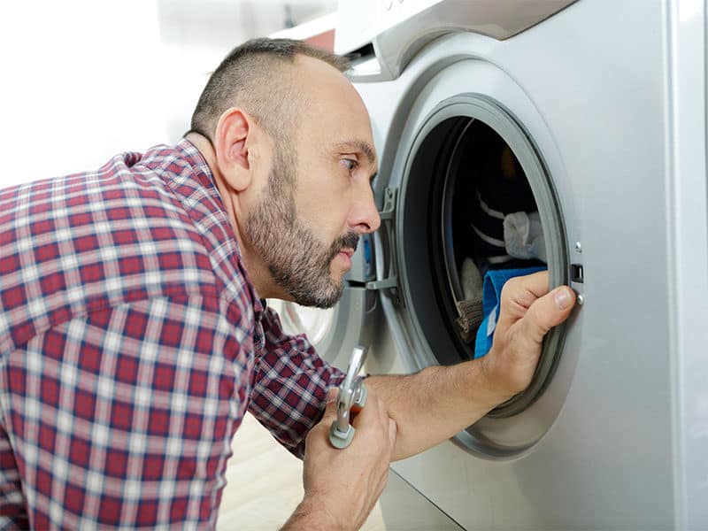 Serviceman Repairing Washing Machine